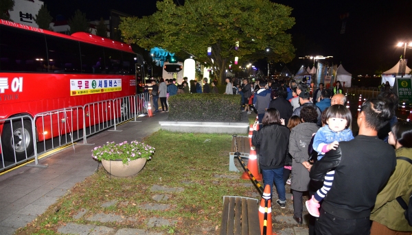 진주시 10월 축제장을 찾은 관람객들이 무료 셔틀버스를 이용하기 위해 줄지어 서 있다.